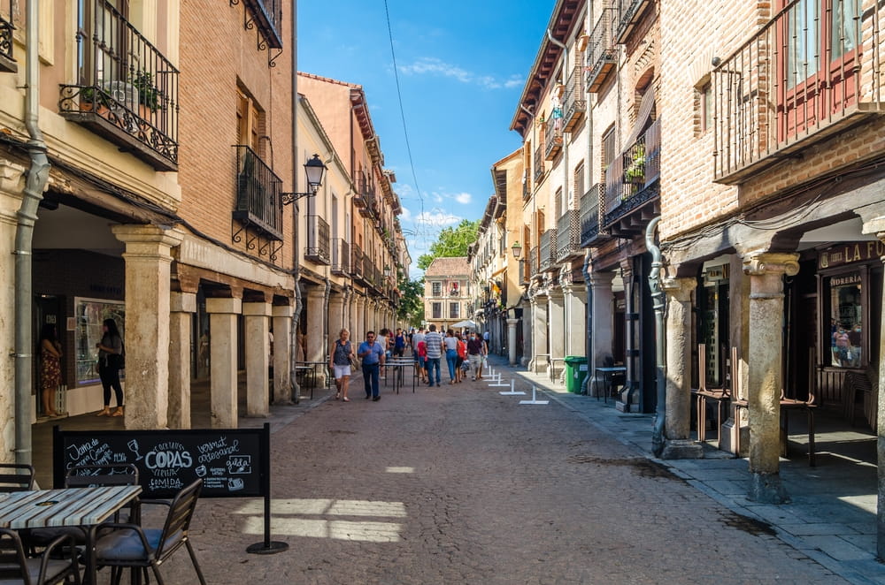 Historic street in Alcalá de Henares near Madrid with arcades, balconies and pedestrians
