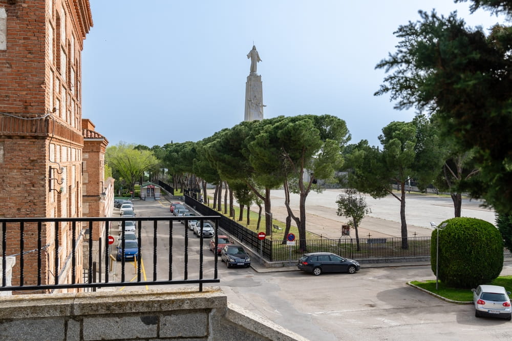 View of Cerro de los Ángeles monument in Getafe near Madrid with trees and parked cars