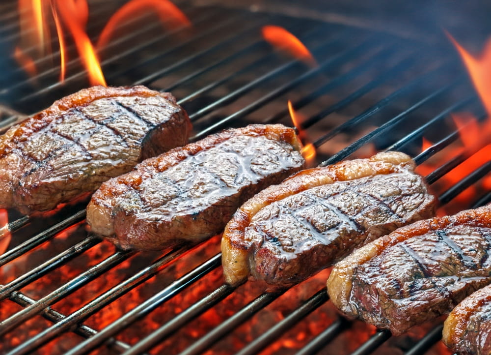 Meat being grilled over an open fire in a Spanish asador